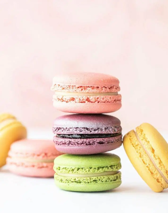 Macarons pastel rose, violet et jaune délicatement empilés